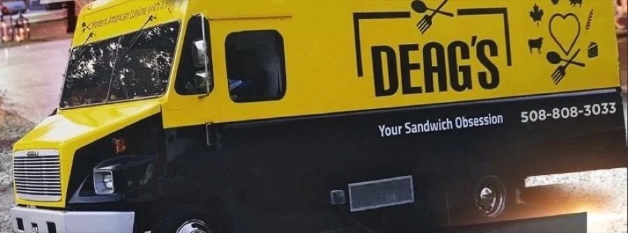 The Deag's On The Go food truck, yellow and black, parked and ready for events